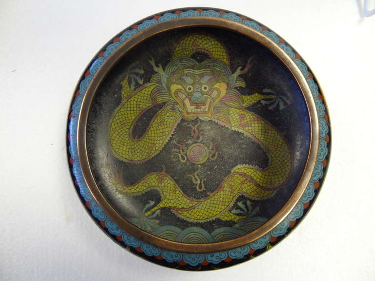 A superb cloisonne piece. Highly colourful Dragons are depicted around the outer edge and there is a further Dragon depicted inside the Bowl. To the base is the mark for the Ming dynasty, though is a faux mark as the period referred to pre-dates the
