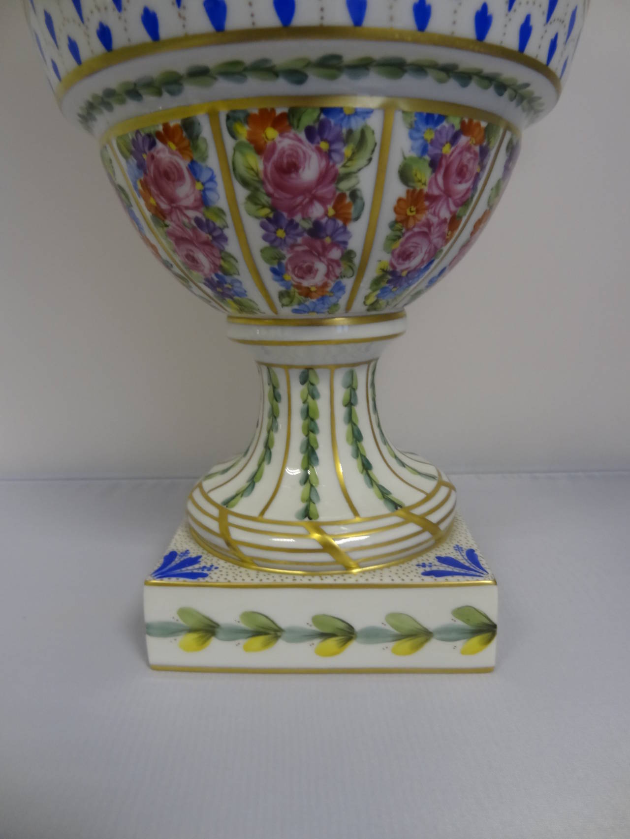 Baluster vase with cover, with intricate panels hand decorated with flowers and floral swags.Handles modelled as rams' heads.
