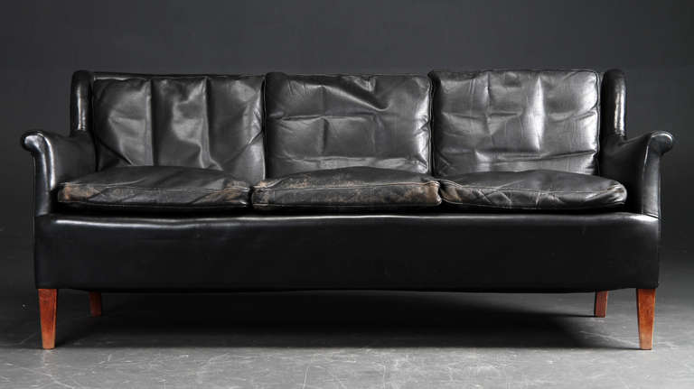 This black leather sofa was made by cabinetmaker Frits Henningsen circa 1940. The original black leather is well patinated and in good condition without any perforations or tears. The backrest reclines significantly, making this a comfortable and