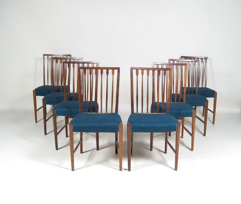 This set of 8 rosewood dining chairs are made of the best Brazilian rosewood with classical features. Made in Denmark c1950, the spindle backs resonate resonate English Windsor chairs. In their original seat covers.