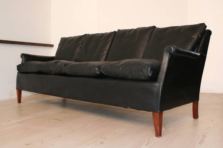 This black leather sofa was made by cabinetmaker Frits Henningsen, circa 1940. The original black leather is well patinated and in good condition with signs of wear and some cracking to leather. The backrest reclines significantly, making this a