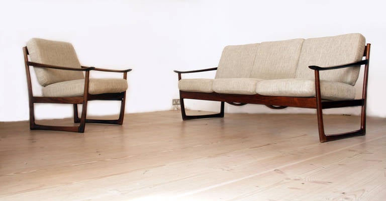 This rosewood sofa and matching armchair was designed by Peter Hvidt & Orla Mølgaard, the pair of architects working in Denmark during 1940-60s. Given the exceptional rosewood frames, these chairs were probably made in the 1950s. The rosewood frames