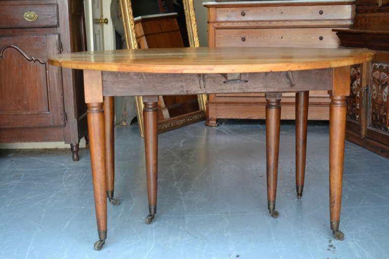 Large 19th Century Blonde French Drop Leaf Table with Turned Legs and Casters.  Grain on this table is beautiful.