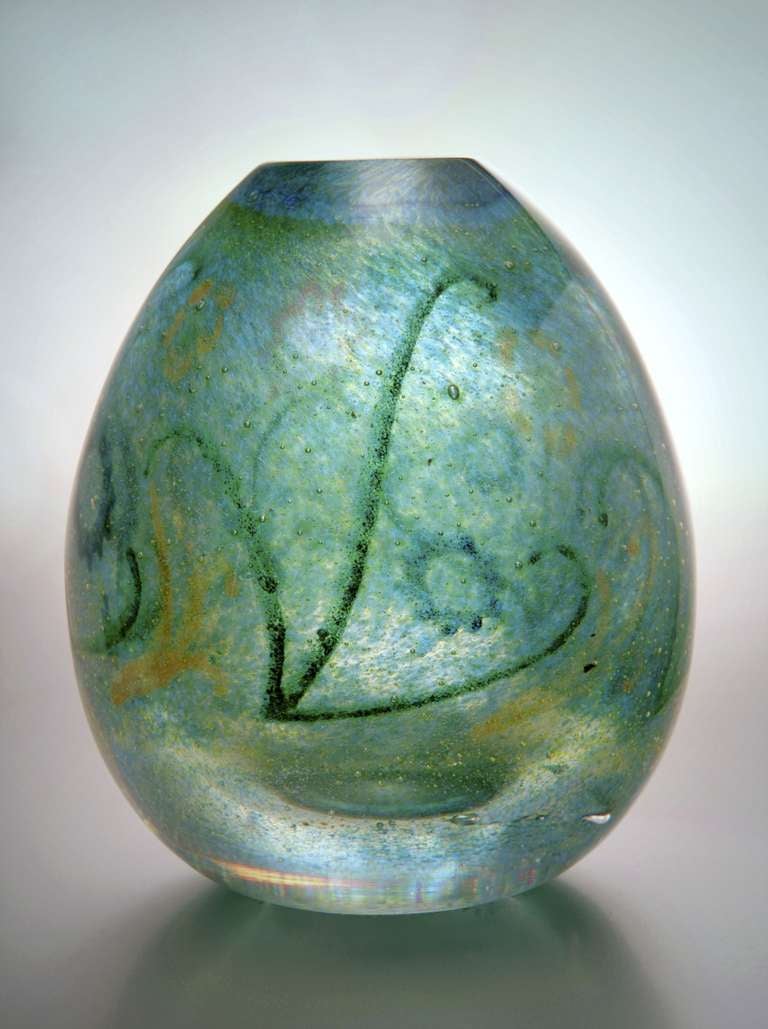 Art Glass vase with vegetal motifs by Andries Dirk Copier. This Leerdam Unica has a thick and slightly bubbly colourless glass core with pulvarised coloured glass in blue, green and yellow tints. The decoration of vegetal motifs is applied in