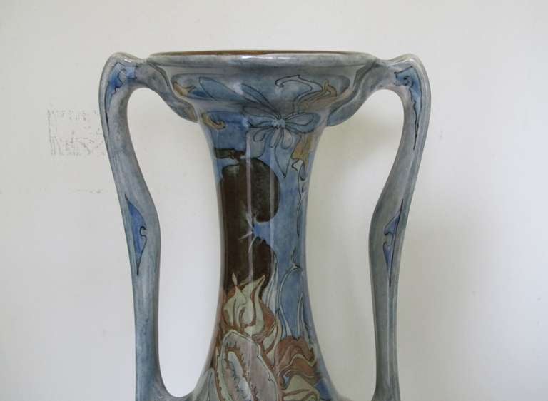 Large twin handled vase with beautiful Art Nouveau floral decor. On the belly of the vase you can see a wilting sunflower clearly inspired by Vincent van Gogh. Also a butterfly sits at the upper part of the neck among other things. 

This is a