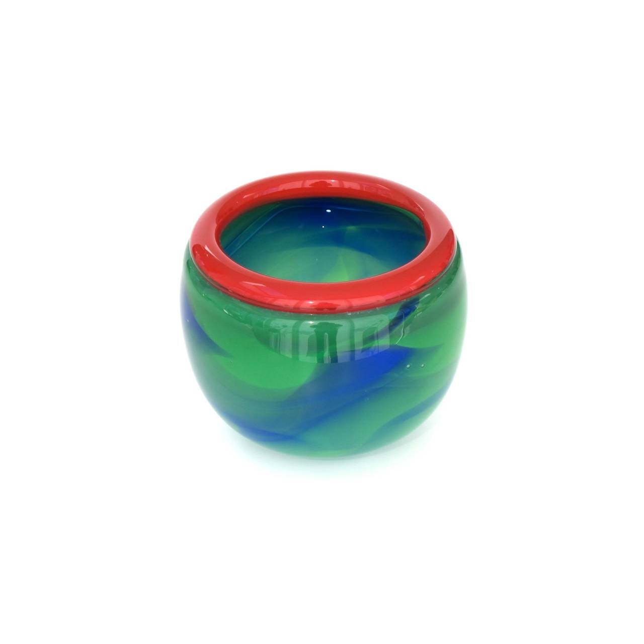 A thick-walled blue and green glass bowl with red rim by Misha Ignis (1953). This piece of art glass is signed 