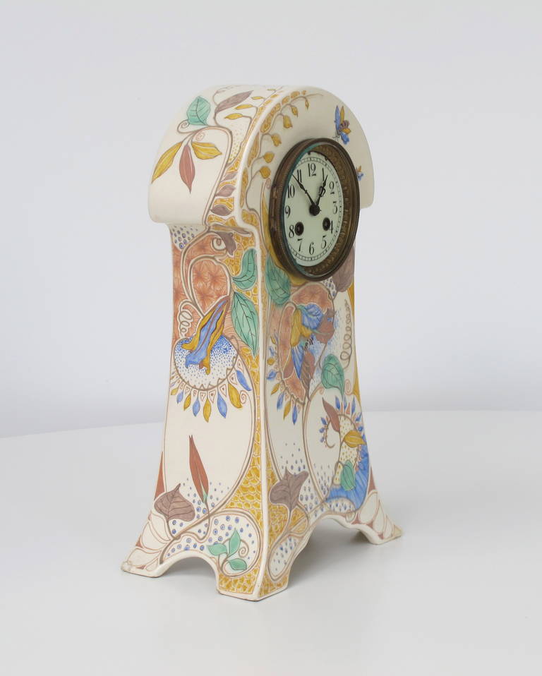 Hand-painted porcelain clock with stunning Art Nouveau decor of flora and fauna under matte glaze. It was produced by the Gouda Royal Faience factory South-Holland.