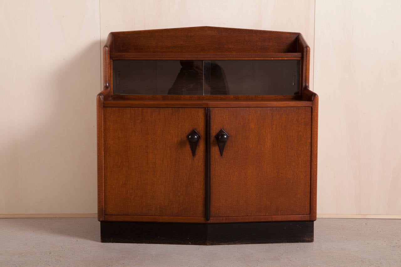 An oak with rosewood tea cabinet in the Amsterdam School style with subtle details by A.F. van der Wey (1885-1969). Van der Wey worked for the furniture factory L.O.V. Oosterbeek, where the cabinet was made during the 1920s. 

The interior of the