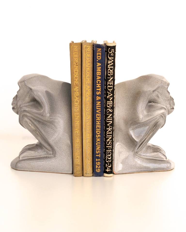 Two Art Deco ceramic bookends depicting squatting monkeys designed by Jan Schonk for Royal pottery factory Zuid-Holland (South-Holland), Gouda. 
Signature:
1 bookend: “’Zuid-Holland’. Jan Schonk”-sticker (on back side); remainder of a seal