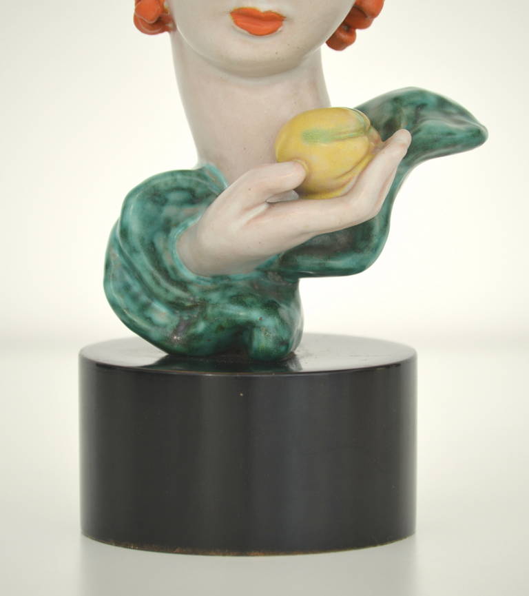 Ceramic mask / bust on round wooden base. This expressive work of Eve with the apple is a perfect representation of Knörlein’s typical style.  It was manufactured around 1933 by the Viennese Goldscheider factory and it is marked on the inside.