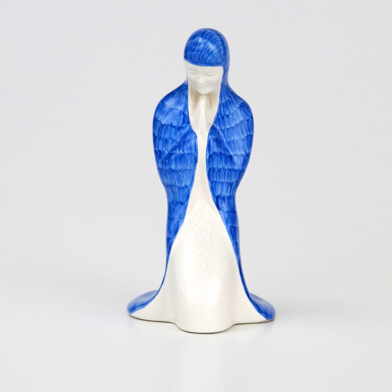 Delicate and serene piece of earthenware by Ed Antheunis for Koninklijke Plateelfabriek Zuid-Holland, Gouda. This kneeled female figure with a blue cloak was made around 1935 of white baking earthenware and has a manufacturer mark on the bottom.