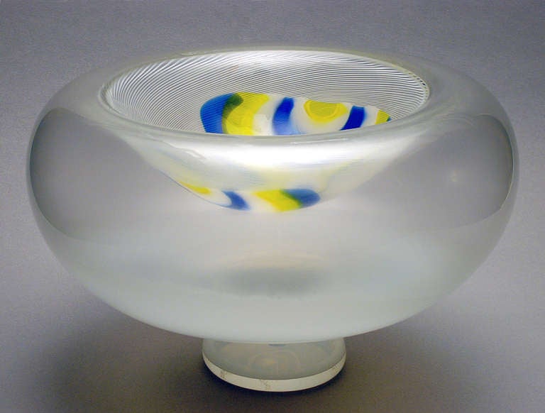 This Tazza-like hollow bowl with spiraling white threading and striking applique´s in blue, yellow and white is a remarkable studio glass one-off. It was made in Murano (Italy) by Andries Dirk Copier in collaboration with master glassblower Lino