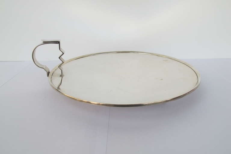 Silver serving platter in modernist style with date letter: 1938.
This platter, made from sterling silver, is marked on the underside with a date letter and town mark indicating: Chester, England from the Chester Assay Office.