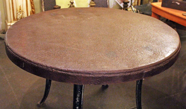 Industrial table hand crafted from artisans from the bottom of a salvaged water tank and an industrial base.