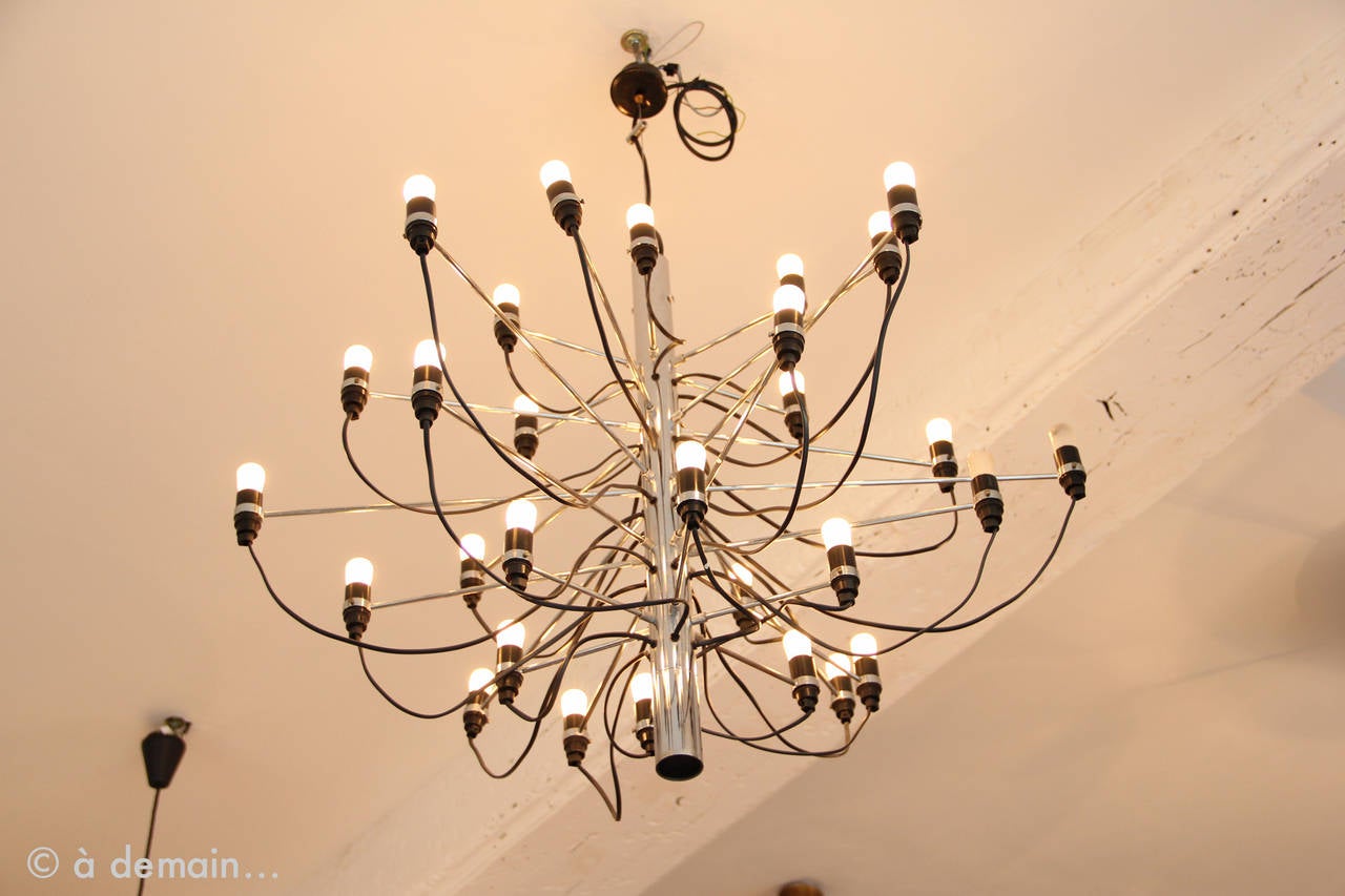 This model is the rare and iconic first edition of the 2097/30 chandelier by Sarfatti and produced by Arteluce in 1958. Very pretty light of this all chrome-plated chandelier of 30 bulbs with bakelite sockets.
This chandelier is no longer produced