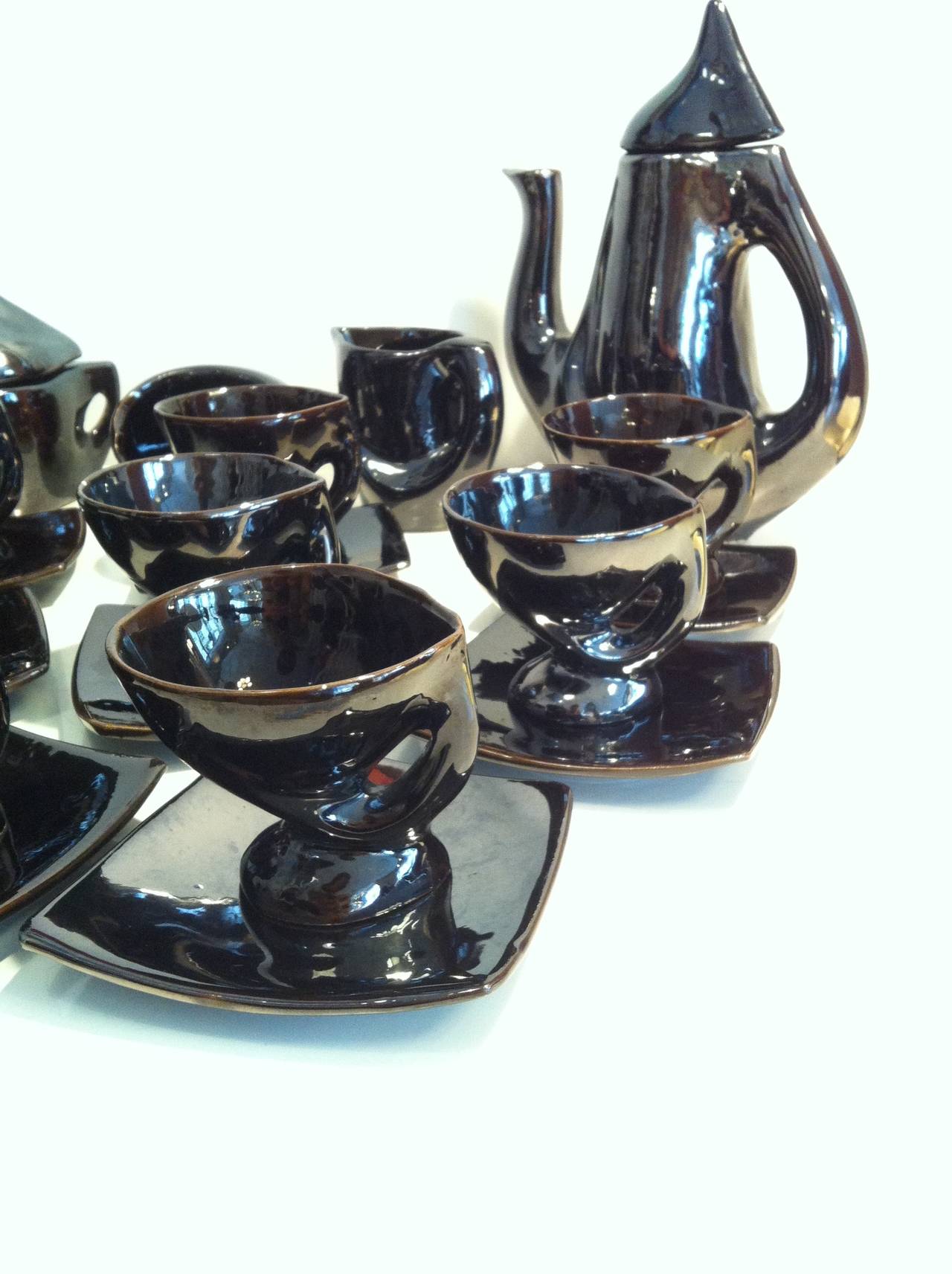 Beautiful and rare 1960s iridescent black tea or coffee service, a Vallauris complete 12 pieces signed set:
- 8 cups with plates (Cup: H. 8 cm x Diameter 9 cm - Plate: 12,5 cm x 11,5 cm)
- 1 Coffee pot with its lid (H. 26 cm x L. 21 cm x P.
