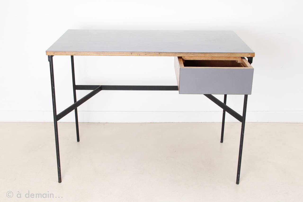 This model is rare thanks to its laminated grey surface.
Made of wood and black lacquered metal structure, the CM174 desk is a rare and instantly recognizable masterpiece of the French designer Pierre Paulin. With its small drawer, its charm is not