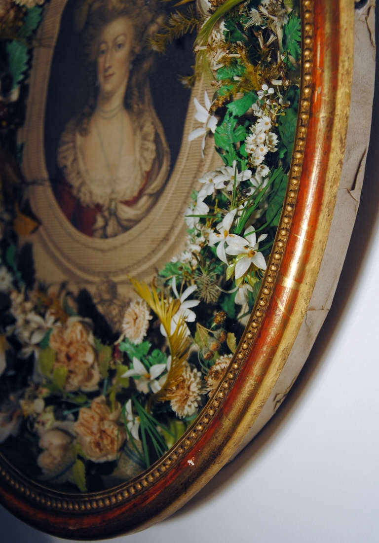 France, circa 1830,

This charming homage represent a colored print of the Queen, wearing around her neck, the medallion of young louis XVII, framed by an arrangement of silk flowers, it is protected by a glass and framed in a lovely gilded wooden