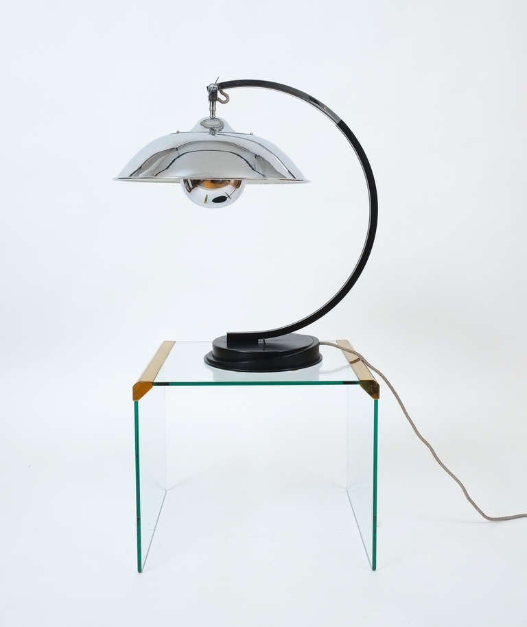 This large desk light was originally designed in 1903 by the spanish textiles and dress designer Mariano Fortuny, the sweepingly curved desk lamp is made of chrome with a solid brass and black lacquered arm and base. By Ecart International.