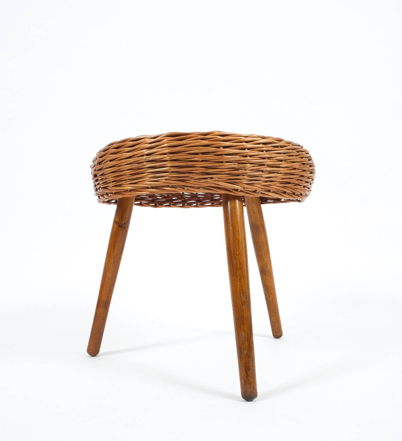 Nice three-legged wicker stool by Tony Paul, 1950 in very good condition featuring a rattan seat and walnut legs.

Shipping is complimentary.