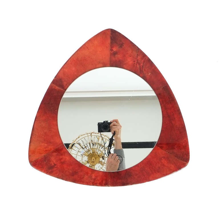 Nice 23 inch mirror by Aldo Tura made from dyed and lacquered goatskin (parchment). It has got an unusual shape and can be hung in multiple ways. The mirror glass measures 14.96 inches in diameter.