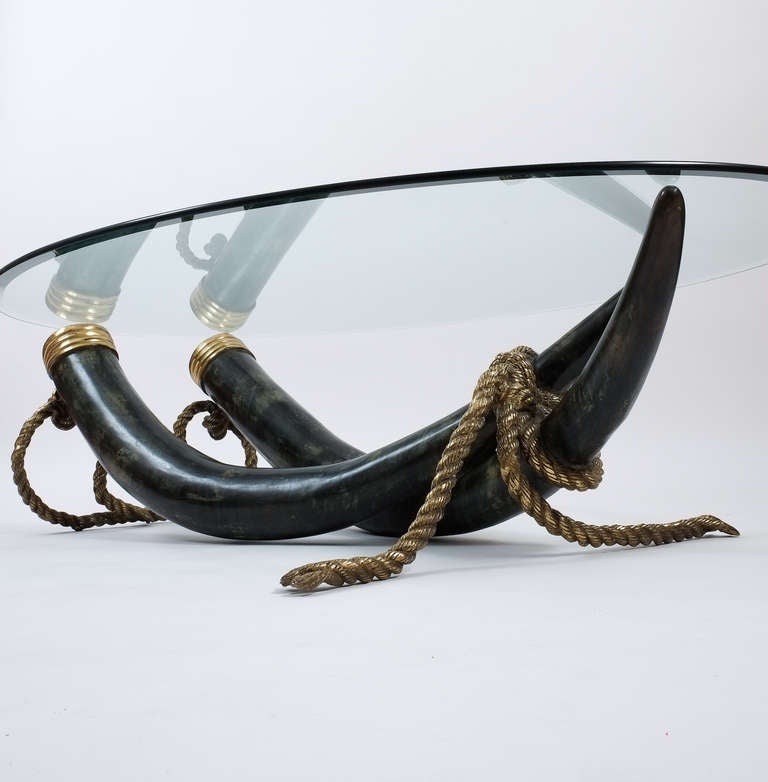 Sculptural bronze base only.

Elephant tusk table base made from bronze cast tusks with brassed parts. A solid bronze 'rope' is stabilizing the ensemble. The condition is good to very good. This offer is for the base only. We recommend having the