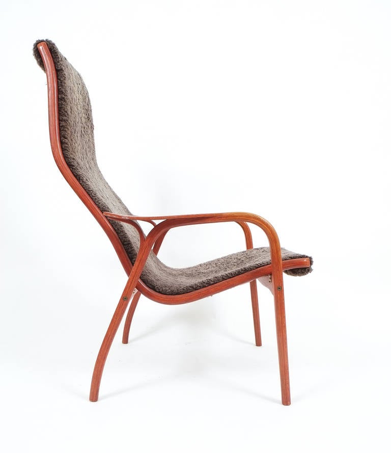 Elegant lightweight lounge chair designed by Yngve Ekström and produced by Swedese, Sweden in 1960s featuring a teak frame and dark grey sheepskin upholstery. The condition is good.