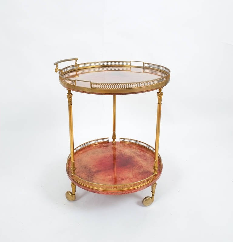 Elegant liquor or bar cart by Aldo Tura Milan, Italy with a removable glass tray. Otherwise it's composed of two dyed and lacquered parchment trays and brass hardware and it's in very good condition. Minimal traces of use are visible.