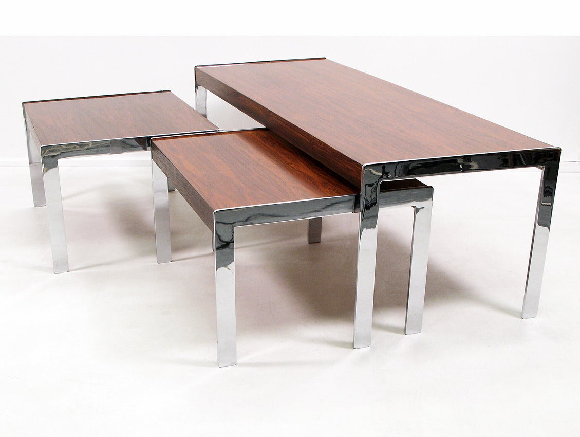 A nest of three striking modernist tables by Richard Young for Merrow Associates, circa 1975.
 
Comprised of Rio rosewood and chromed steel, these impressively-sized tables combine beauty with functionality.
 
They have been lovingly