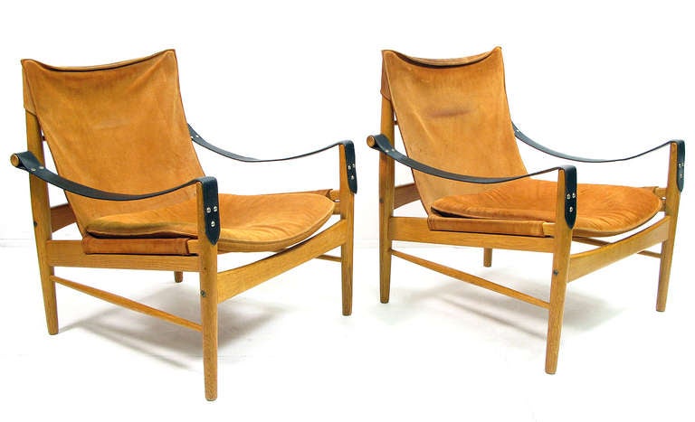 A pair of 1960's low safari chairs in pine, leather and suede by Hans Olsen.  The finely crafted wood frames are fitted with tan suede upholstery and black leather armrests. The frame and suede structure is very strong and in excellent condition.