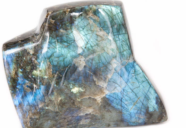 Labradorite is a feldspar mineral with the quality of ‘labradorescence’, in which the mineral reflects light to give it a remarkable glow. The polished face of the mineral glows a different colour from each viewing angle; this specimen has gold,