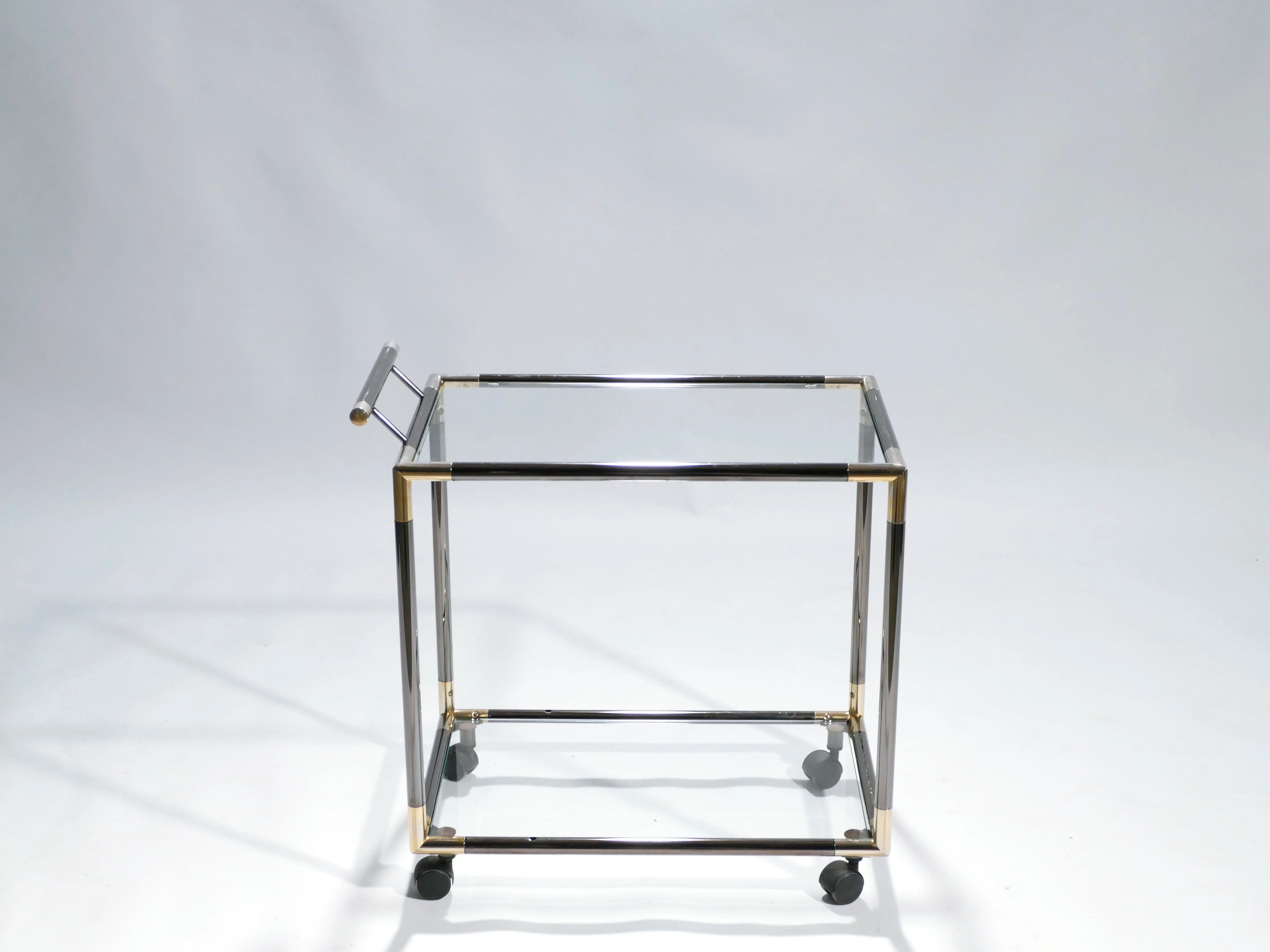 The designer of this pair of gunmetal and brass bar cart aimed to emulate the simple structure and visual drama of Maison Jansen’s iconic style. Sleek lines and an ordinary rectangular structure are offset by bright brass joints at all four corners.