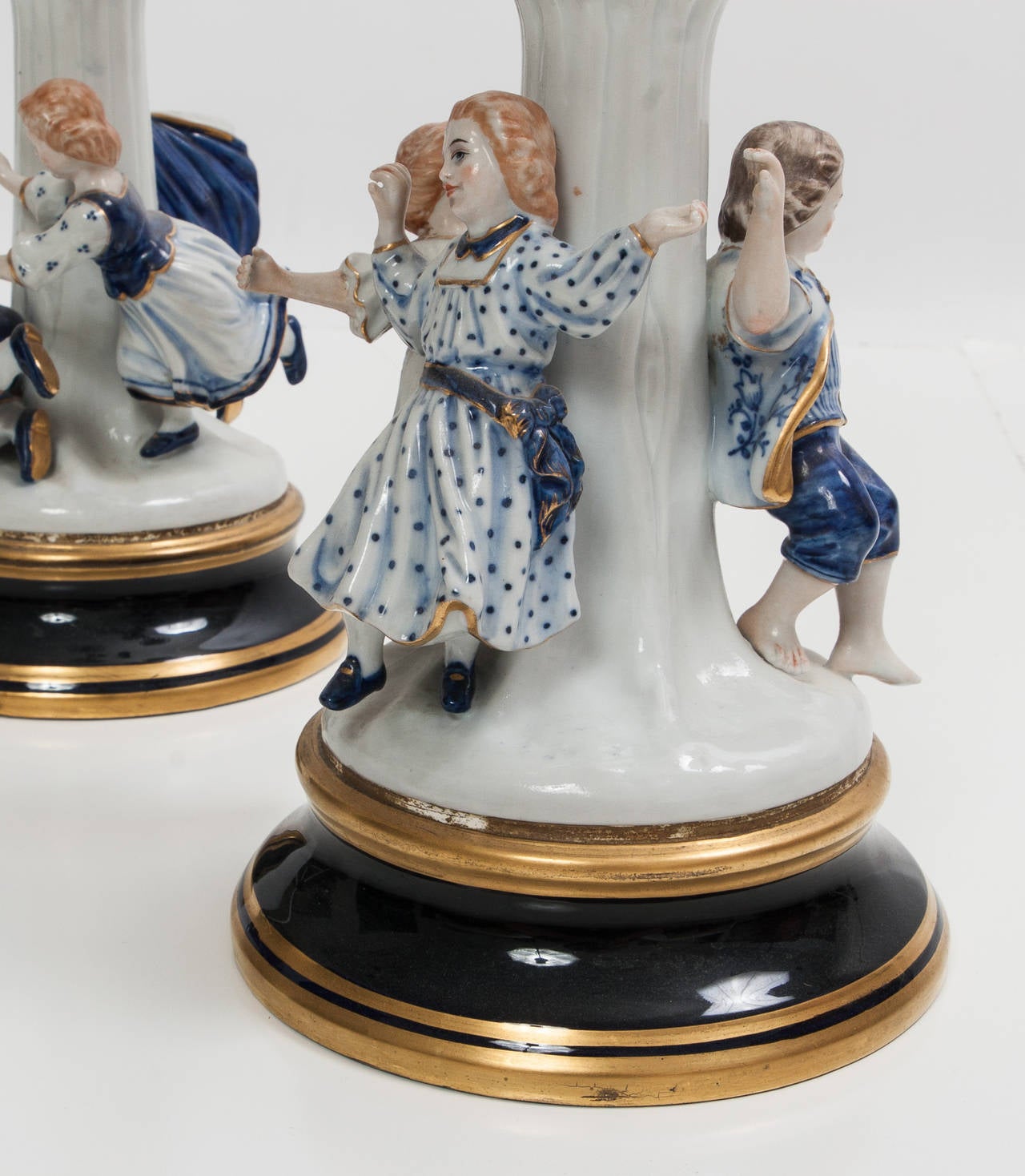 Italian candelabras with blue and white with figures of children at base.