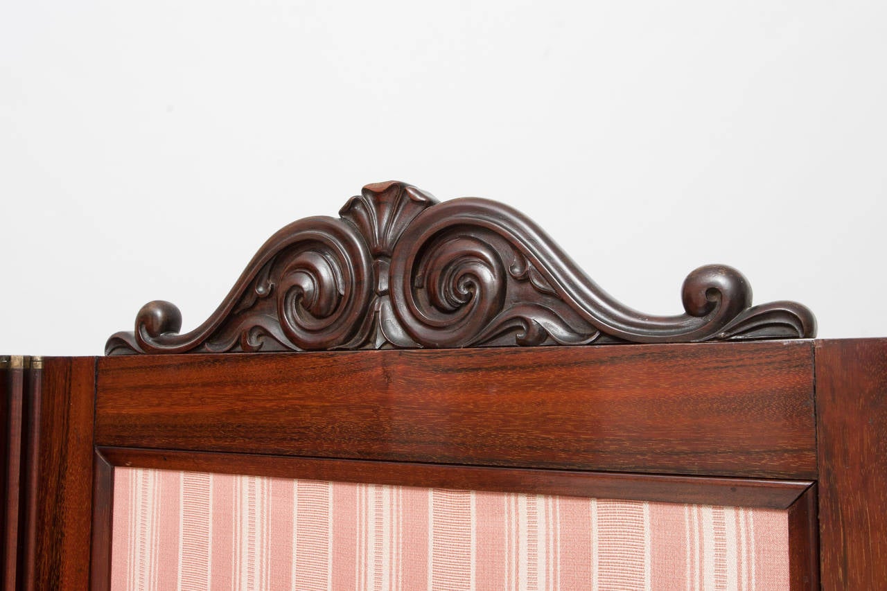 French Two-Panel Screen in Mahogany with carved mahogany-veneered panels that frame salmon patterned fabric