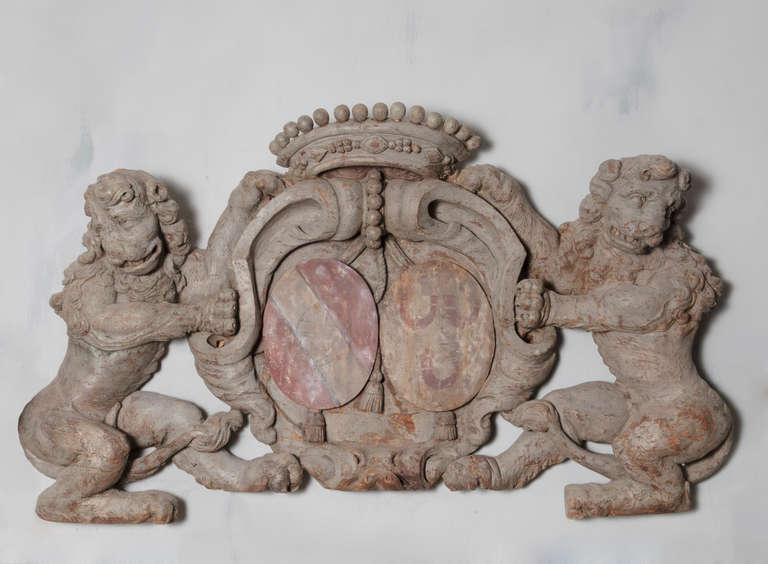 Early 18th century beautifully wood carved Dutch carving of pair of lions and coat of arms in a grey washed patina with a faint red and gold painted coat of arms. This carving features 2 lions holding a coat of arms all intricately carved with crown
