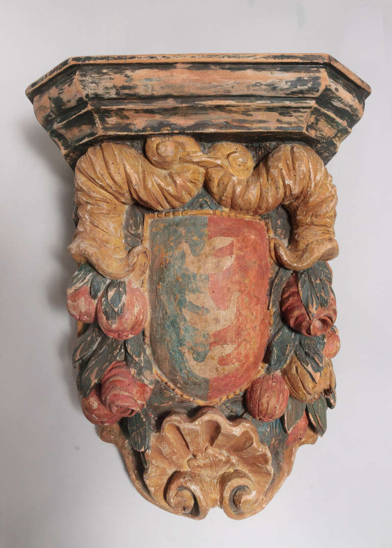 This 18th century Italian Baroque Polychrome beautifully carved and colored pine bracket is very impressive. The colors are in faded blue, orange and gold. The bracket has a shelf on the top and a shell design in on the bottom portion.  The Italian