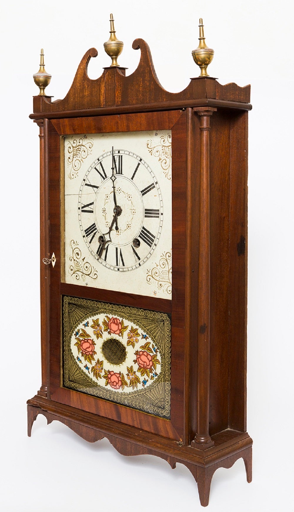 American mahogany pillar and scroll mantel clock by Eli Terry, circa 1820. American mahogany pillar and scroll mantel clock with carved scrolled pediment, brass finials, original works, all parts present, reverse painted glass of fine floral design