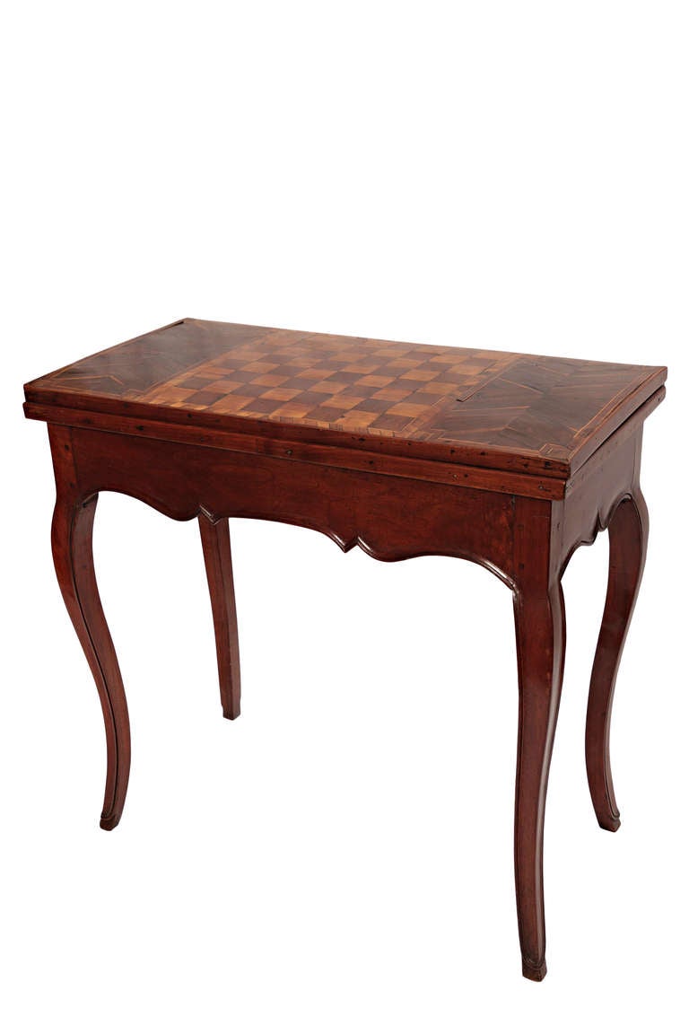 Gaming table in fruitwood veneer. Has checkerboard top and folds out to green felt covering, circa 1790-1800.