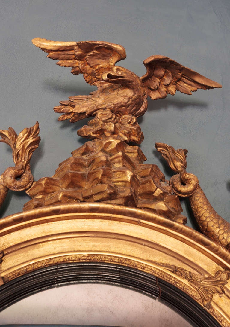 Regency Bull's-Eye Mirror with Hippocampus decoration surmounted by an eagle with gilt finish.