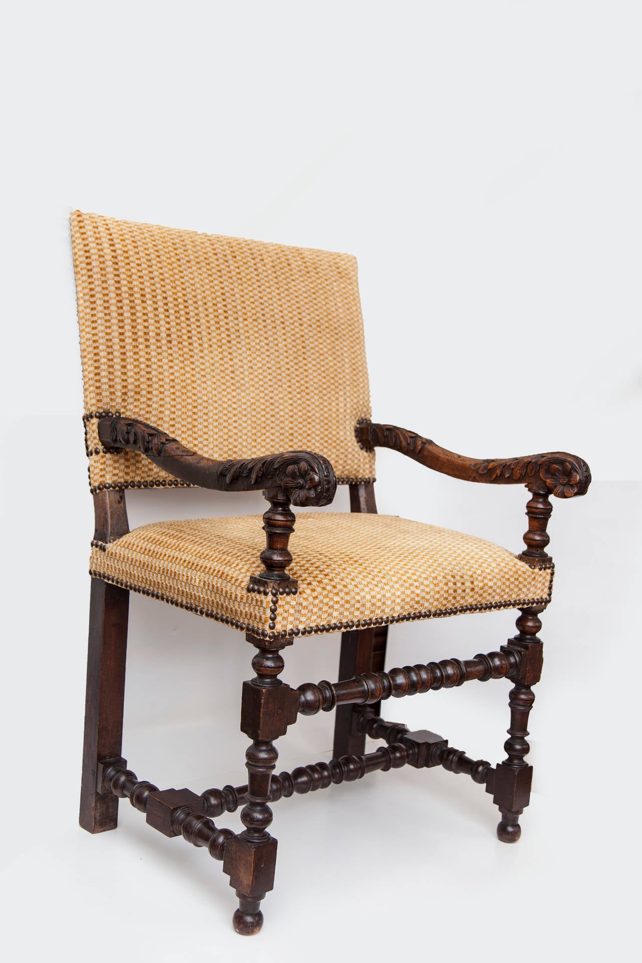 18th century French Louis XV armchair in Italian Renaissance style with nailhead trim and carved walnut arms and legs. Cut velvet in colors of gold and cream upholstery.