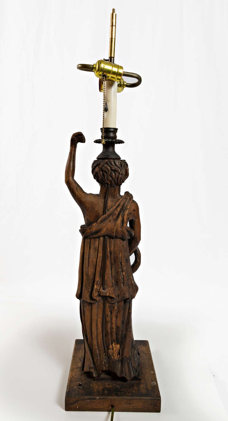 19th Century lamps of Walnut beautifully carved mythological ladies with snakes coiled around their bodies mounted on a square base with square lampshades. With the shade the height is 33 inches tall.