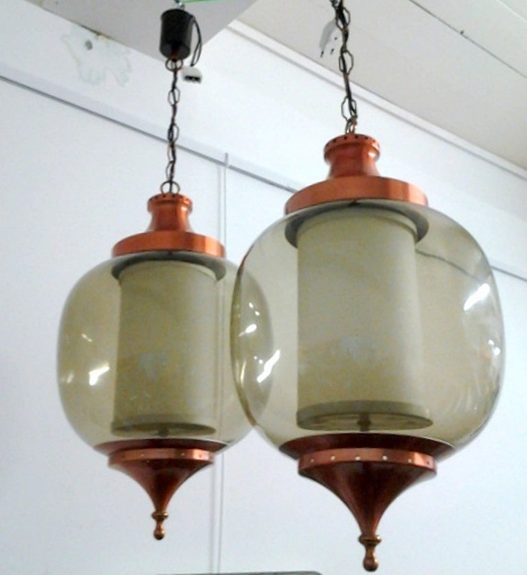 Pair of French lanterns in copper and blown glass with inside a white glass cylinder to hide the lights bulbs .
