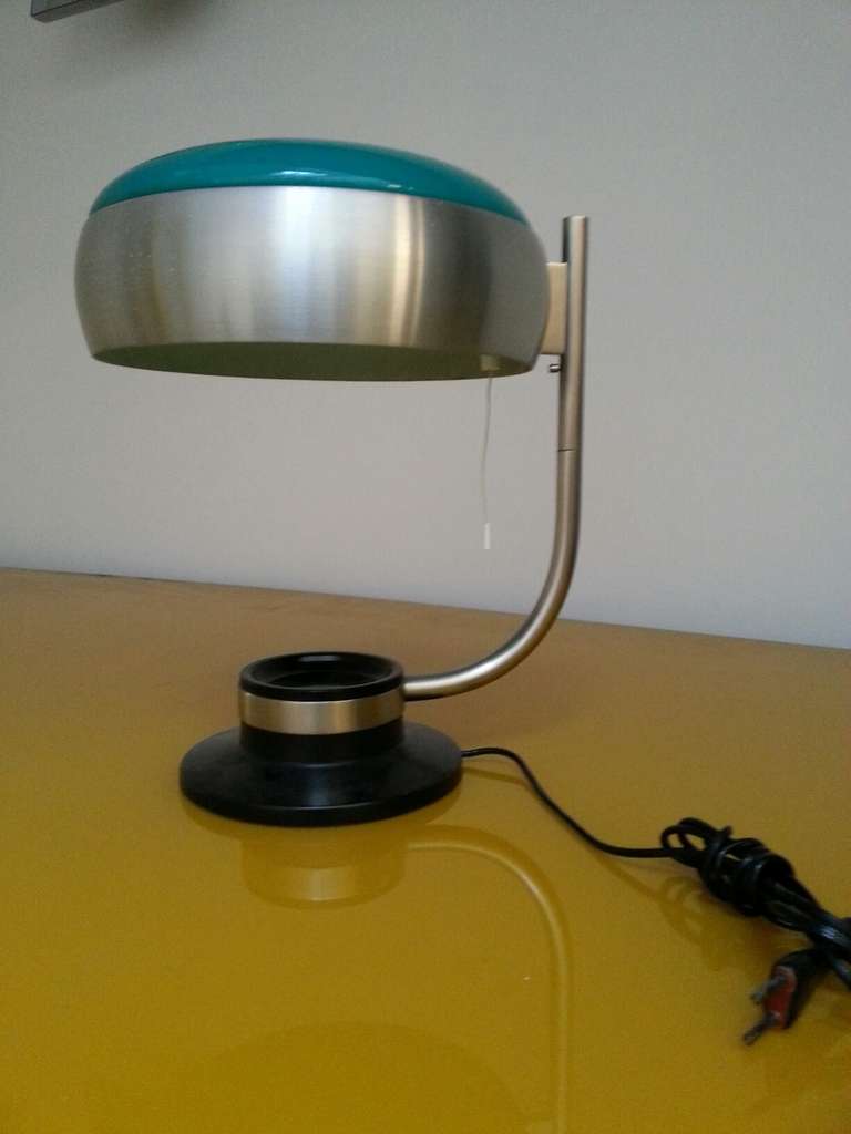 Early 1960's table lamp by Oscar Torlasco,  stainless steel and glass top-
The top part of the lamp can swivel to give the light different directions .