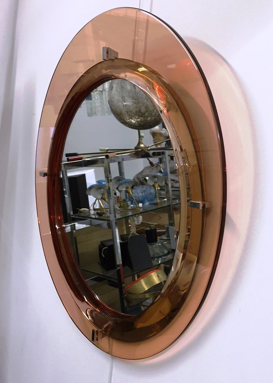 Elegant round mirror with chromed details and pink glass frame