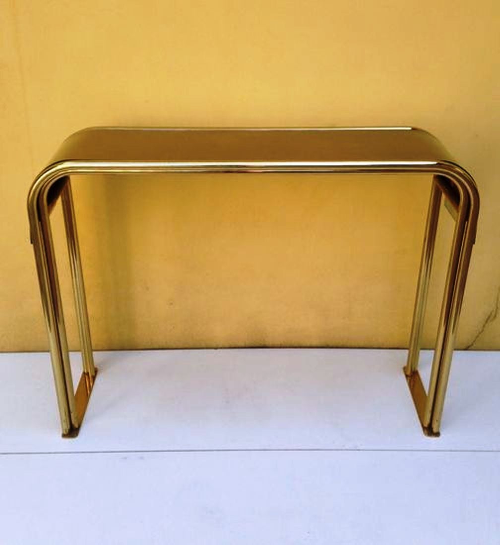 Elegant 70's console table , brass structure , curved plywood and curved glass top .