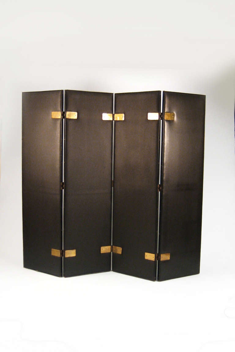 Four-panel folding screen covered in black skai, stitched along the edge and affixed with brass hinges. 

   