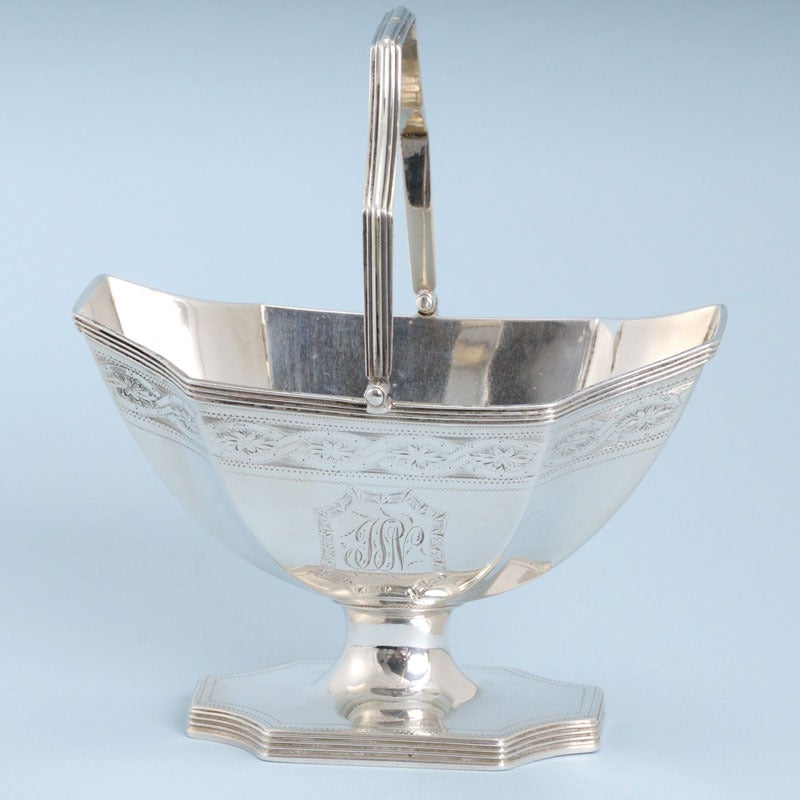 Very decorative and extremely well made George III sterling silver swing-handled sugar basket. Made by Henry Chawner in London in 1791. The body of the basket is octagonally shaped, as is the foot. The handle is shaped and reeded and there is a band