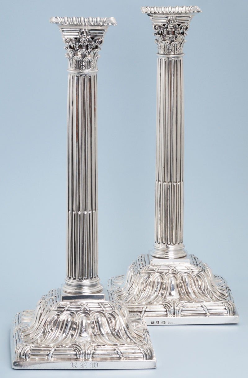 Imposing and well above standard, pair of silver George III, tall Corinthian filled candlesticks on square bases. Made in London in 1761 by Ebenezer Coker. The columns are fluted, very much in the style of William and Mary candlesticks. The heavy