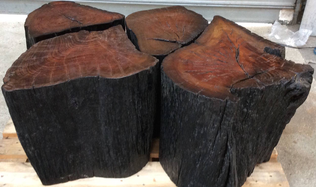 Set of four solid iron wood stools with black sides and reddish tops, making a very contemporary round or rectangular coffee table.