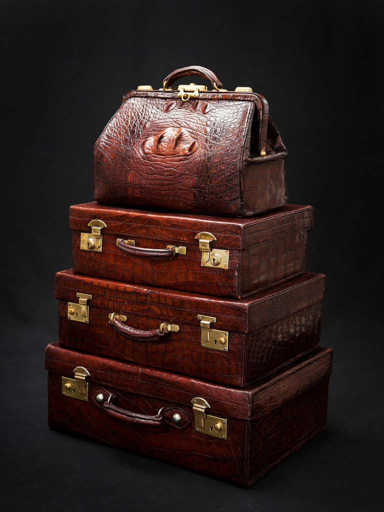 Three crocodile leather suitcases and a Gladstone crocodile bag, all from the early 20th century. All items are vintage English craftsmanship.

This rare collection is in remarkably excellent condition.
A unique investment opportunity. 

The
